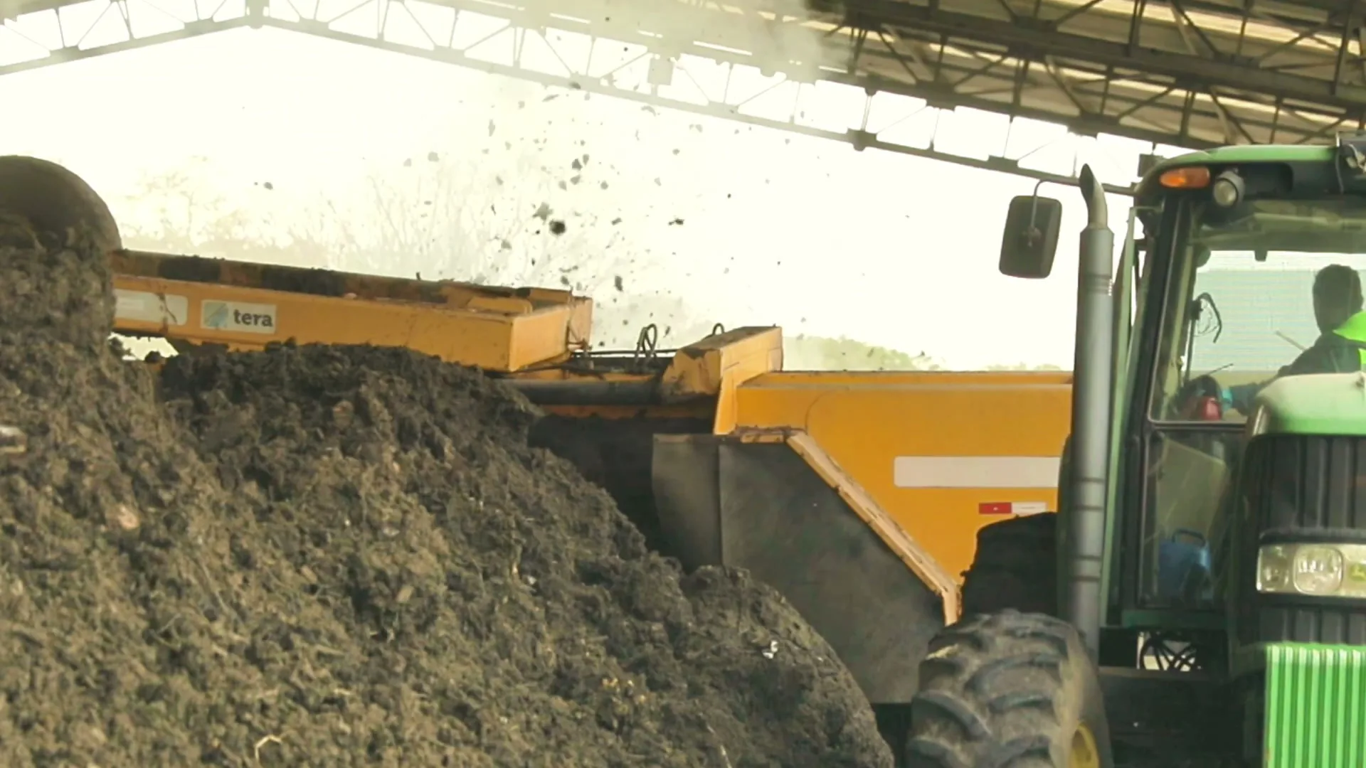 A tractor operator turns a composting windrow inside the Tera facility.